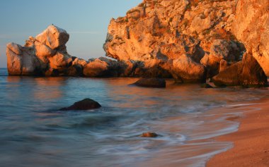 Kayalıklar'günbatımı arka plan ile deniz plaj