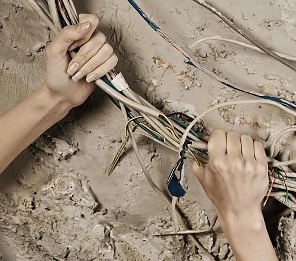 Женщина хватает за руки провода, чтобы разорвать его. — стоковое фото