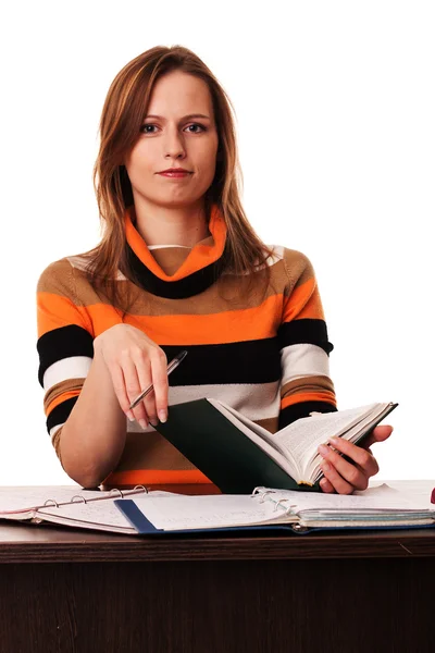 Jeune femme tenant un livre et un stylo assis au bureau — Photo