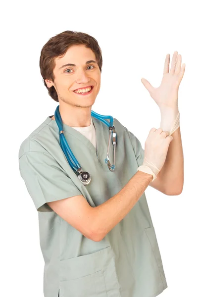 Glückliche junge Ärztin zieht Handschuhe an — Stockfoto