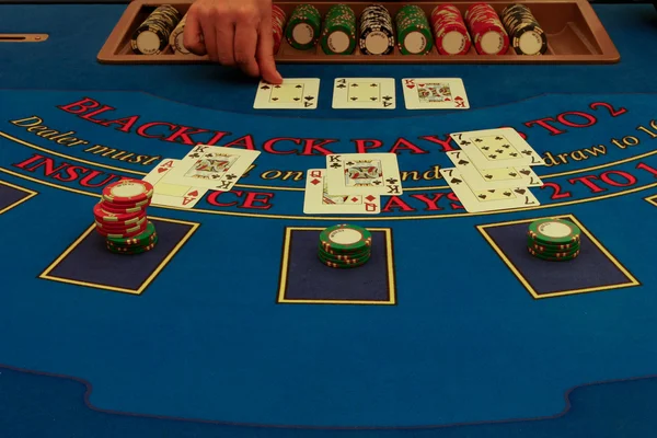 Distribuidor distribuye cartas en mesa de blackjack — Foto de Stock