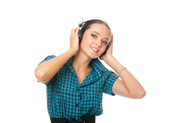 Wanita muda yang ceria mendengarkan musik dengan headphone besar dan melihat — Stok Foto