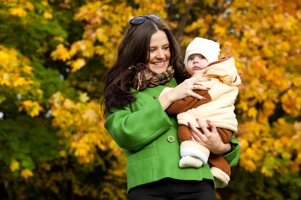Jonge moeder met baby in armen omhoog — Stockfoto