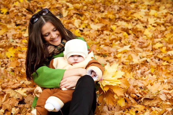 Ung mamma hålla barnet i park — Stockfoto