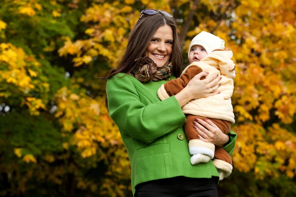 Mãe feliz segurando bebê no parque — Fotografia de Stock