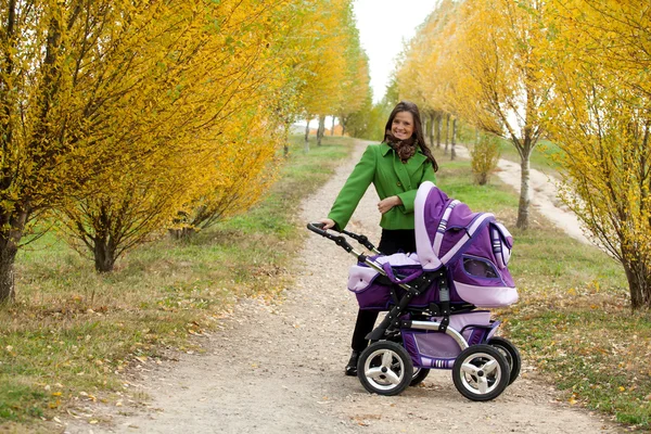 Junge Mutter mit Kinderwagen — Stockfoto