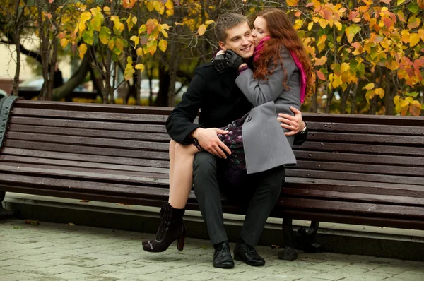 Mooi meisje zit op haar vriendje knieën — Stockfoto