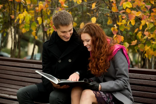 Fiatal pár azt fontolgatja egy könyv — Stock Fotó