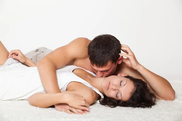Молодой человек целует женщину — стоковое фото
