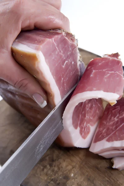 Skivor av bacon på träplatta med kniv — Stockfoto