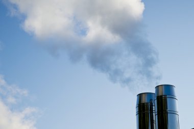 endüstriyel baca üzerinde mavi gökyüzünün dumanı