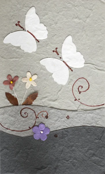 Бумажная бабочка с цветком на сером фоне — стоковое фото