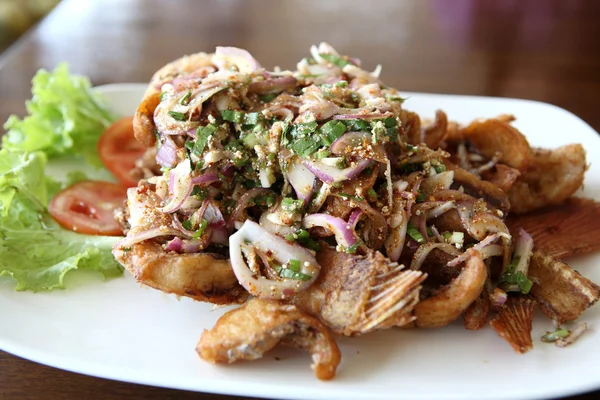 Cibo tailandese pesce fritto con insalata di erbe piccante su sfondo di legno — Foto Stock