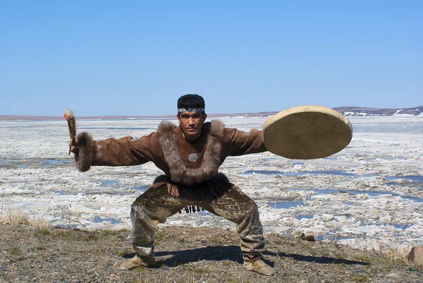Chukchi Mann tanzt einen Volkstanz gegen die Frühlingslandschaft Stockbild