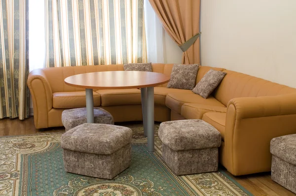 Kanapa i okrągły stół w apartamencie — Zdjęcie stockowe