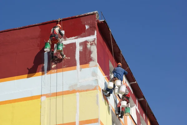Steeplejacks pintando a casa contra o céu azul — Fotografia de Stock