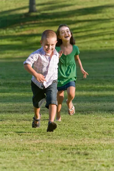 Двое маленьких детей бегают и играют — стоковое фото