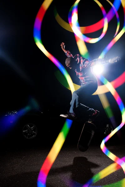 Skateboardista s abstraktní světlé stezky — Stock fotografie