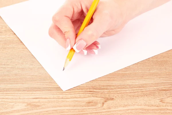 Женская рука, карандаш и бумага — стоковое фото