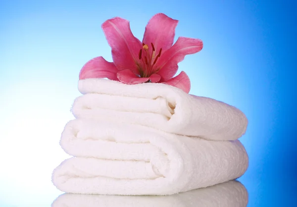 Stack of towels with pink lily — Stock Photo, Image