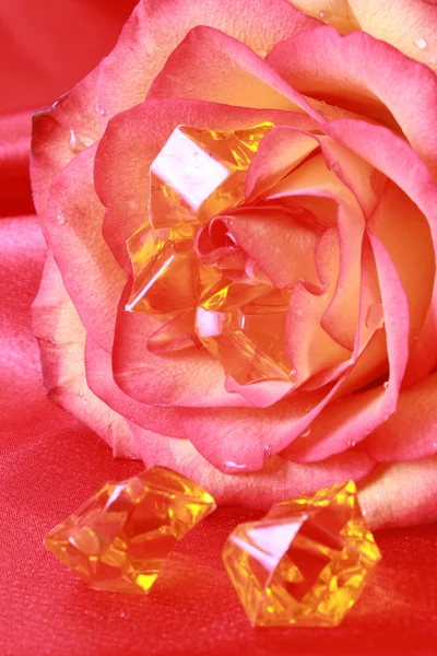 Rosa e pedras preciosas sobre fundo vermelho — Fotografia de Stock