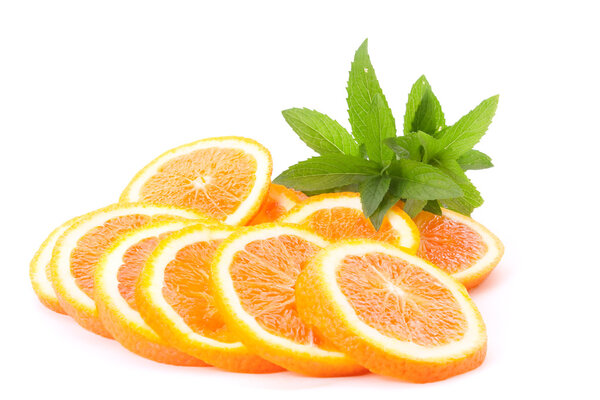 Many sliced oranges and green plant isolated on white