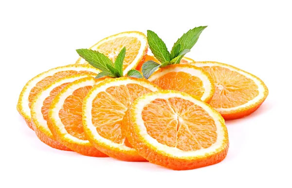 Mnoho plátky pomeranče a zelených rostlin izolovaných na bílém — Stock fotografie
