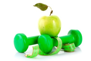 Dumbbells, green apple and measuring tape isolaeted on white