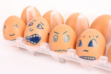 Group of brown hen's eggs with different faces in the box clipart