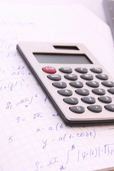 Calculator on notepad with calculations — Stock Photo, Image