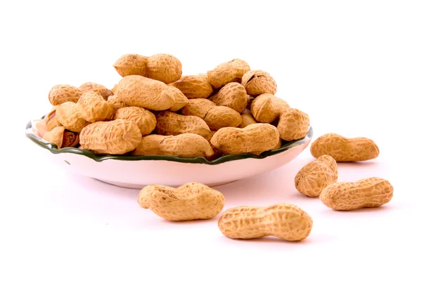 Poucos amendoins e prato isolado em branco — Fotografia de Stock