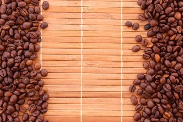 Kávové zrna na hnědé pozadí — Stock fotografie