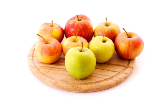 Kilka jabłek na drewnianej tacy na białym tle — Zdjęcie stockowe