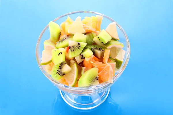 Cup with orange, kiwi and lime on blue — Stock Photo, Image