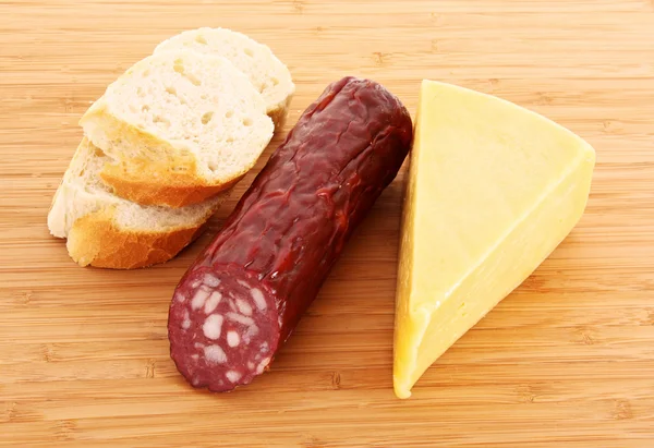 stock image Sausage, bread and cheese on wooden plate