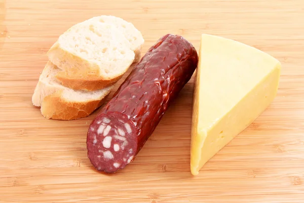 stock image Sausage, bread and cheese on wooden plate