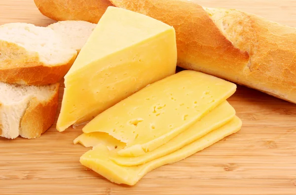 나무 식탁에 놓인 치즈와 빵 — 스톡 사진