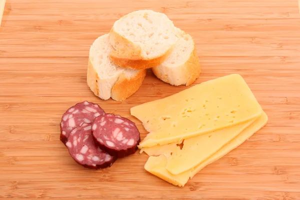 stock image Sausage and bread on wooden surface