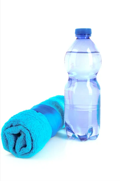 Gedrehtes blaues Handtuch und eine Flasche sprudelnden Wassers isoliert auf — Stockfoto