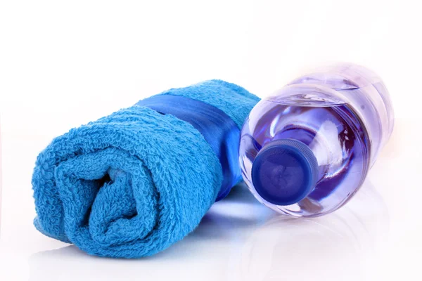 Στριμμένα μπλε πετσέτα και μπουκάλι νερού απομονώνονται σε whi — Φωτογραφία Αρχείου