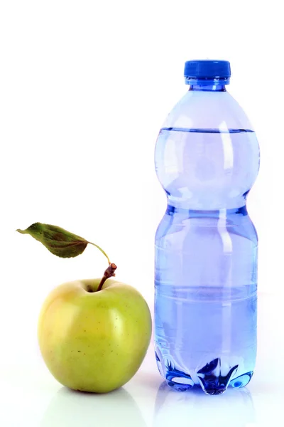 Butelka wody gazowanej i zielone jabłko na białym tle — Zdjęcie stockowe