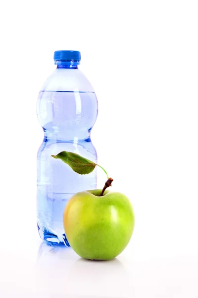 Botella de agua con gas y manzana verde aislada sobre blanco — Foto de Stock