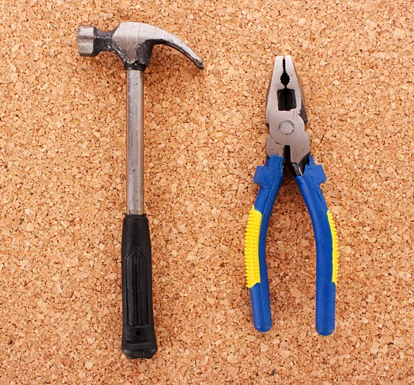 Hammer und Zange auf Korkplatte — Stockfoto