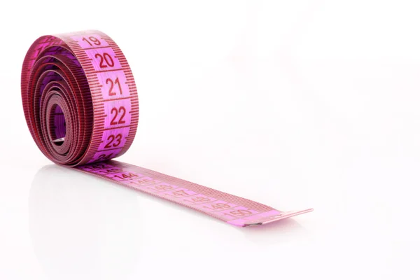 白で隔離されるピンクの測定テープをツイスト — ストック写真