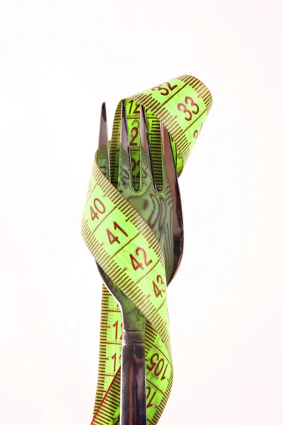 Green measuring tape on the fork isolated on white — Stock Photo, Image