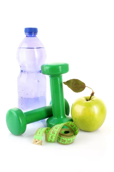 Hantlar, grönt äpple, mätning av tejp och en flaska vatten iso — Stockfoto