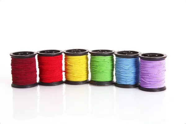 Gekleurde spoelkokers van wol geïsoleerd op wit — Stockfoto