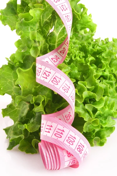 Green fresh lettuce with pink measuring tape — Stock Photo, Image