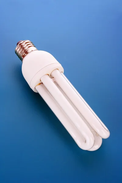 Ampoule à économie d'énergie sur bleu — Photo