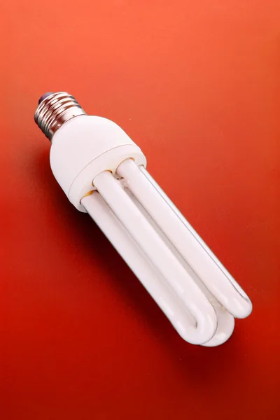 Energiebesparende lamp op rood — Stockfoto